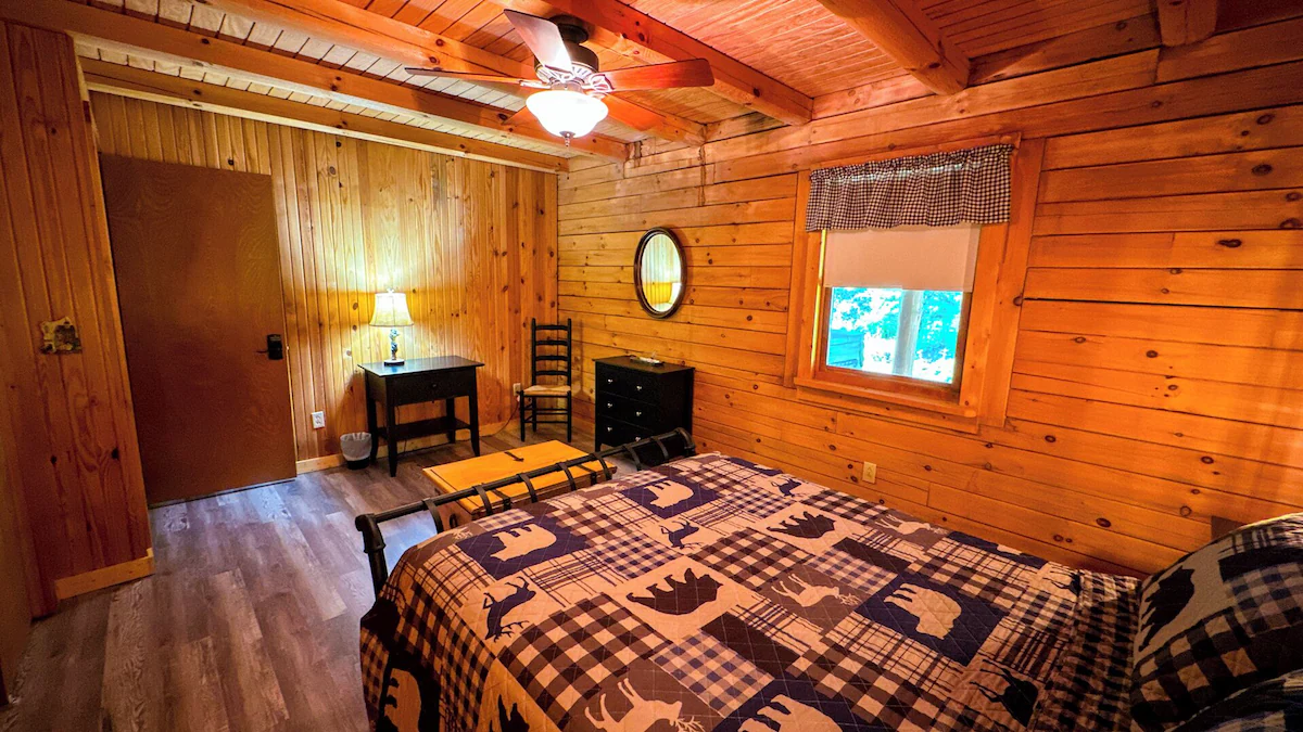 Cabin seen through surrounding woods.