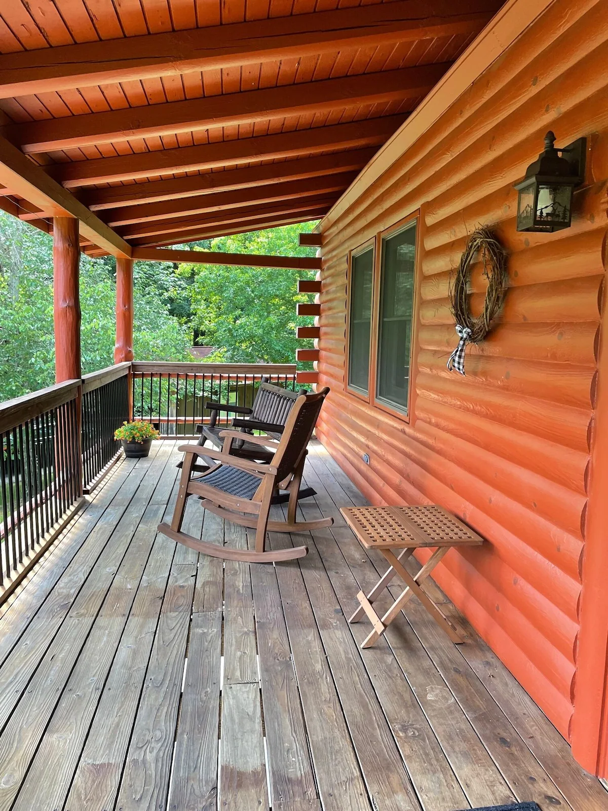 Covered porch with two rocking chairs looking out into the treetops.