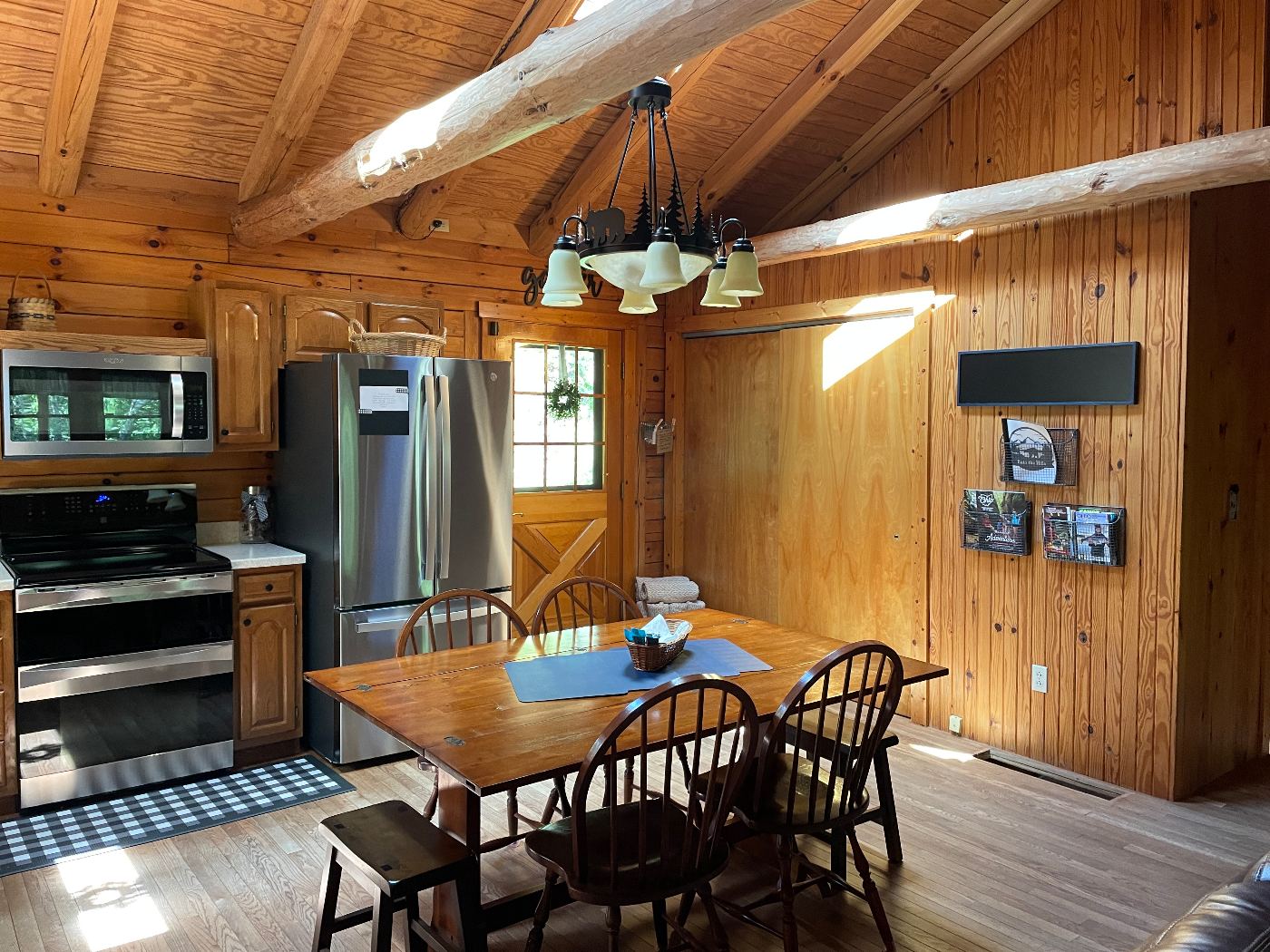Dining table and range beneath peeled log beams and a skylight.