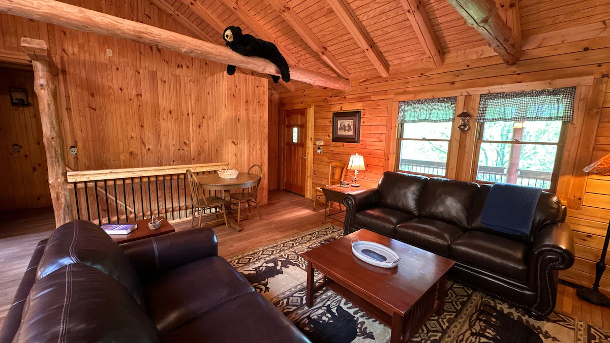 Upstairs sitting area with two leather sofas and windows facing the porch.